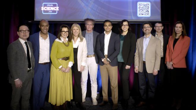 Group of people dressed professionally smiling and standing on a stage