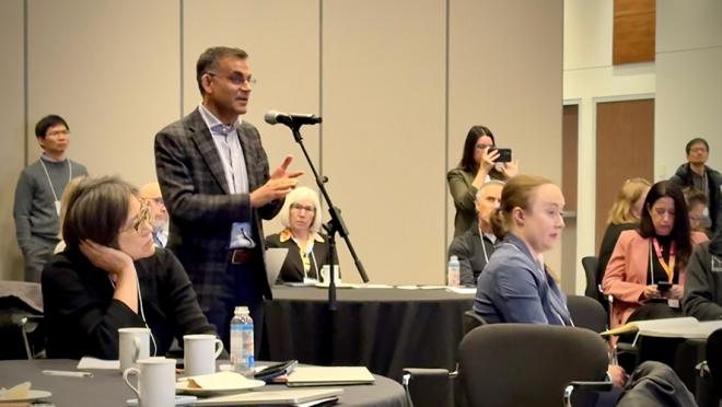 Dr. Vasdev at the microphone asking a question during a talk