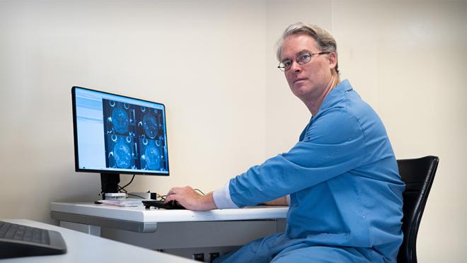 Dr. Warren Foltz looking at MRI images on a computer monitor.