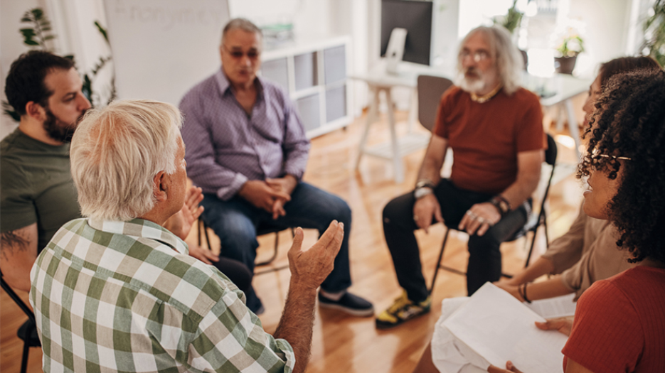 Older  adults sitting in a circle discussion.