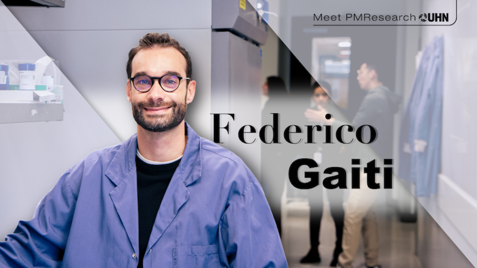 Smiling man wearing glasses and a blue lab coat standing in a research lab