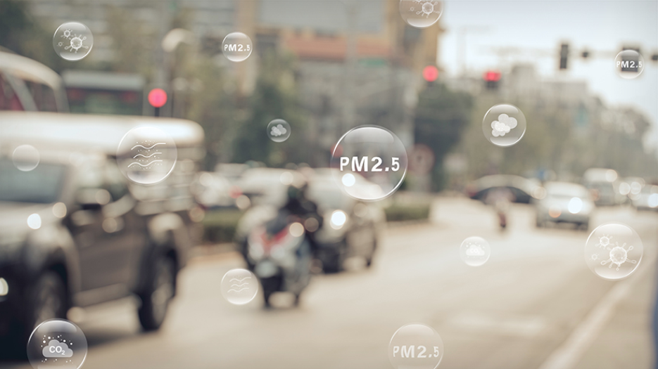 Photograph of busy city street that looks hazy with illustrated bubbles containing the words PM2.5 inside.