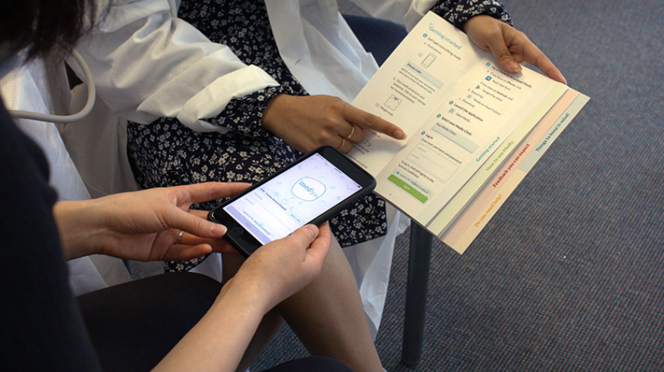 Image of a patient and a doctor looking at the medly application and information