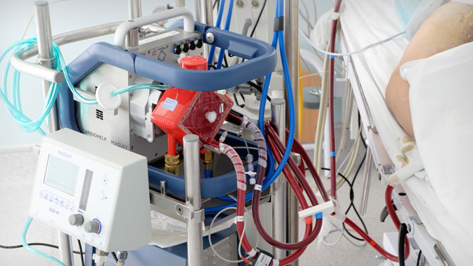 The ECMO machine functions as an artificial lung by delivering oxygen directly to the blood and clearing carbon dioxide from the blood.