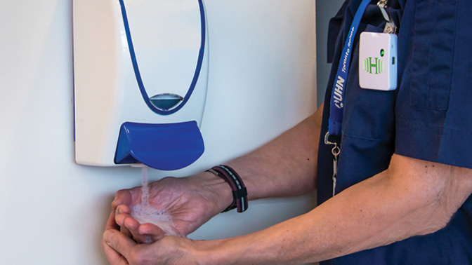 Proper handwashing with alcohol-based hand sanitizer can help prevent infection. This photo shows the badge invented at UHN. Image credit: Barry Westhead, TRI