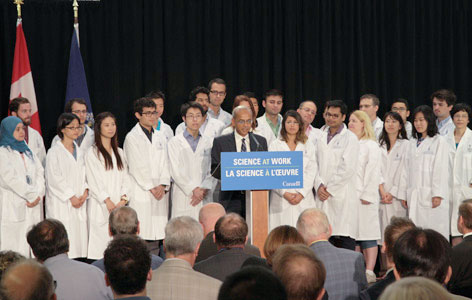 University of Toronto Vice President Research Professor Vivek Goel addresses the audience at the Canada First Research Excellence Fund announcement while trainees look on.
