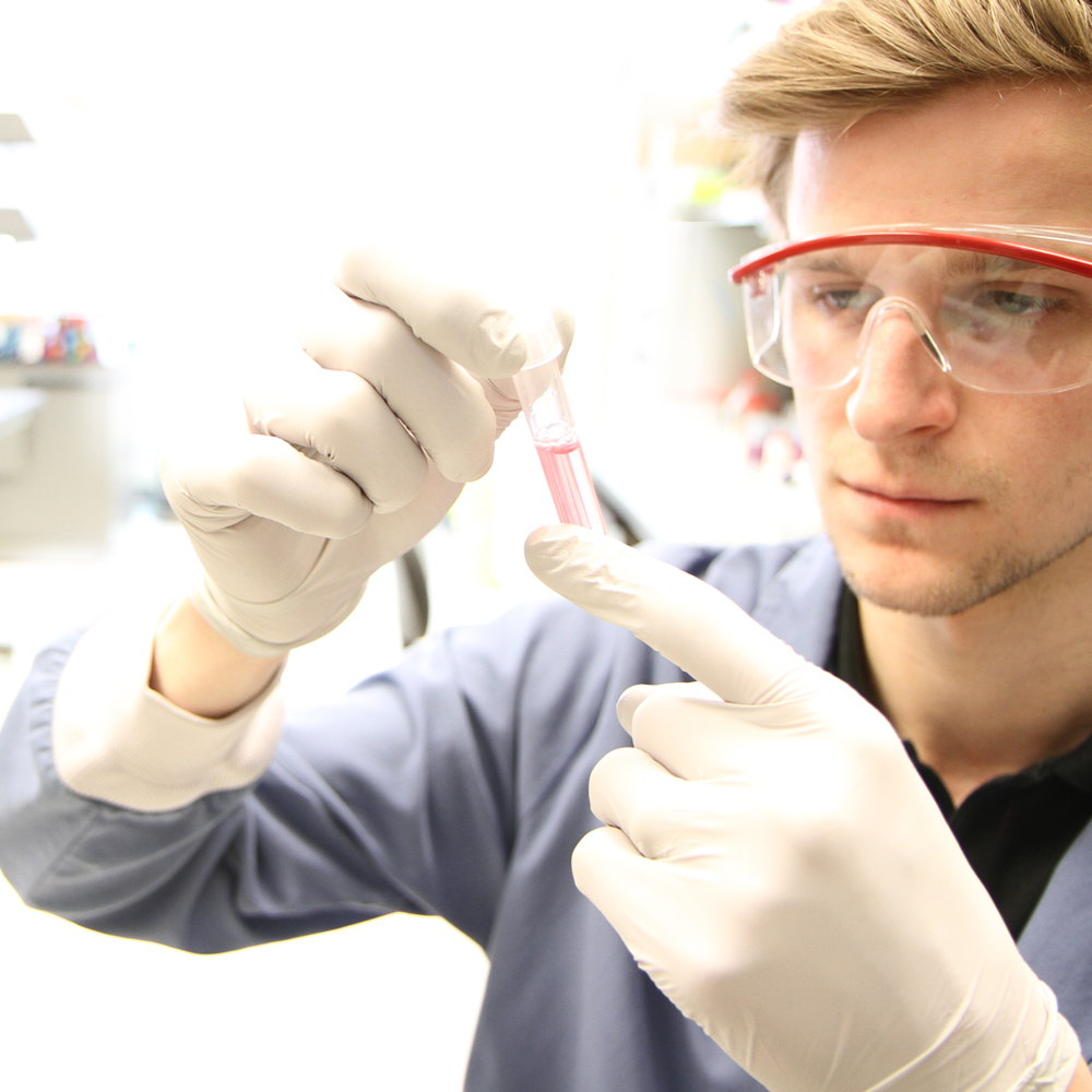 Scientist holding up lab test tube