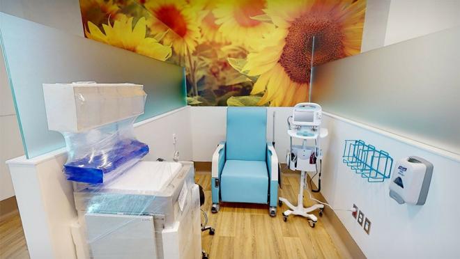 Photo of patient medical space with chair and medical equipment.
